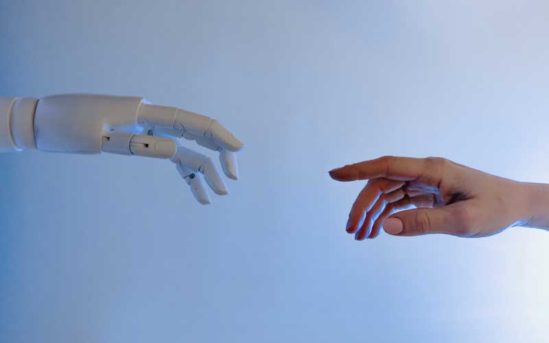 Mano de un robot y mano humana