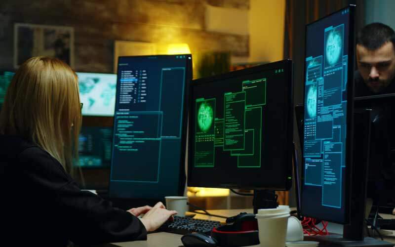 Mujer programando en una sala con ordenadores